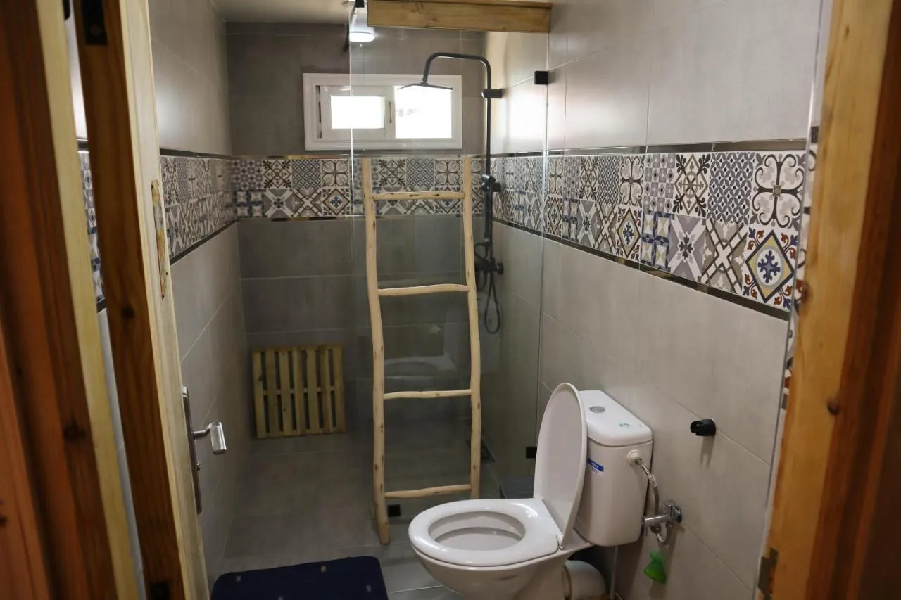 A shared bathroom at Gripsea in Anza with patterned tile and a glass shower