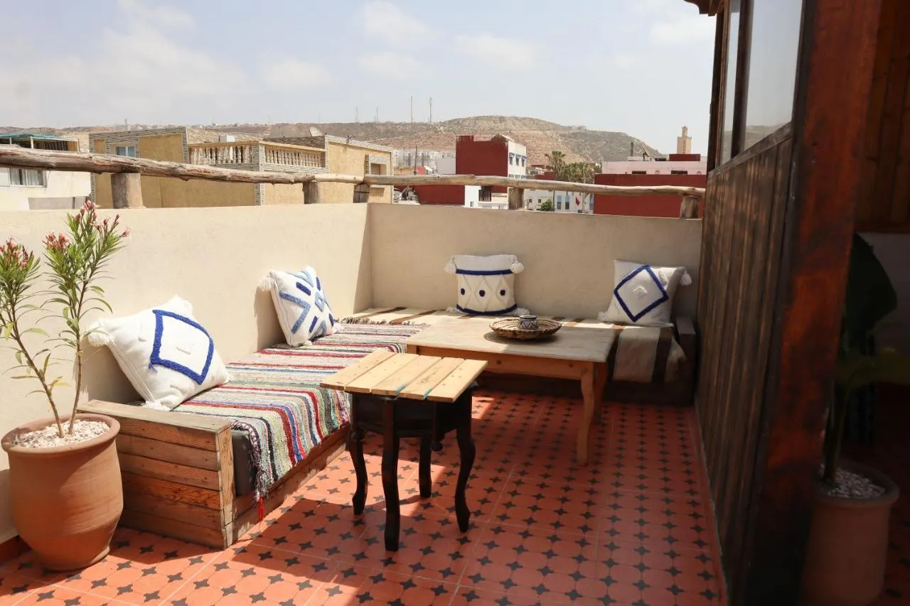 The sunlit rooftop terrace at Gripsea in Anza, with cushioned seating and Moroccan tiles